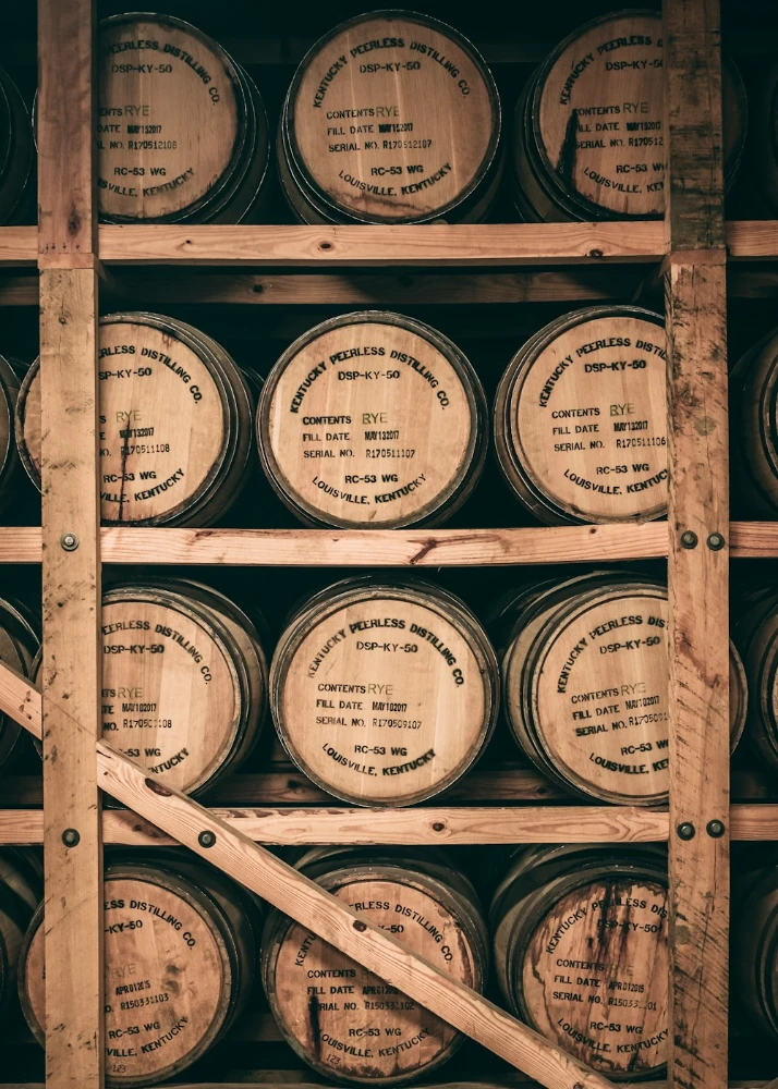 Whiskey barrels stacked on wooden racks in distillery